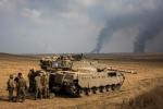 SDEROT, ISRAEL - JULY 22: Israeli soldiers stand near their tank while smoke due to airstrikes and shelling rises from Gaza on July 22, 2024 near Sderot, Israel. As operation 'Protective Edge' goes into it's third week, the death toll continues to mount, including 27 Israeli soldiers and over 500 people in Gaza, the vast majority of whom are civilians. Credit Andrew Burton/Getty Images