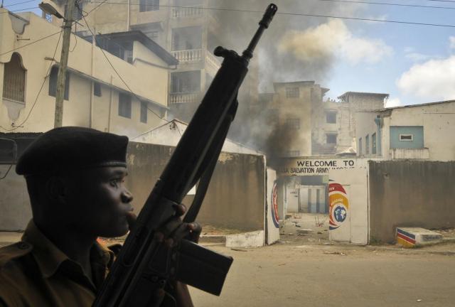 An armed police officer stands guard in front of the Salvation Army Church after it was set on fire by rioting youths, following Friday Muslim prayers in Mombasa, Kenya, Friday, Oct. 4, 2013. An armed police officer stands guard in front of the Salvation Army Church after it was set on fire by rioting youths, following Friday Muslim prayers in Mombasa, Kenya, Friday, Oct. 4, 2013.