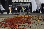 People pass next to tomatoes thrown by demonstrators in the entrance of the International Trade Fair during a protest against austerity measures and the layoff of public workers on September 7, 2024 in Thessaloniki. AFP PHOTO /Sakis Mitrolidis