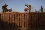 Men work at a brick-making factory outside Kabul