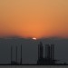The sun sets over an oil platform waitin
