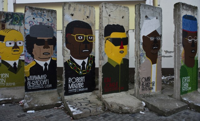 Concrete slabs from the former Berlin wall are decorated with likenesses of (from R) Chad's President Idriss Deby, Sudan's President Omar Al-Bashir, former North Korean leader Kim Jong-il, Zimbabwe's President Robert Mugabe, and Burma's President Thein Sein, by French artist Guillaume Kashima, near the city's Checkpoint Charlie area in Berlin on January 13, 2013. AFP PHOTO / JOHN MACDOUGALL