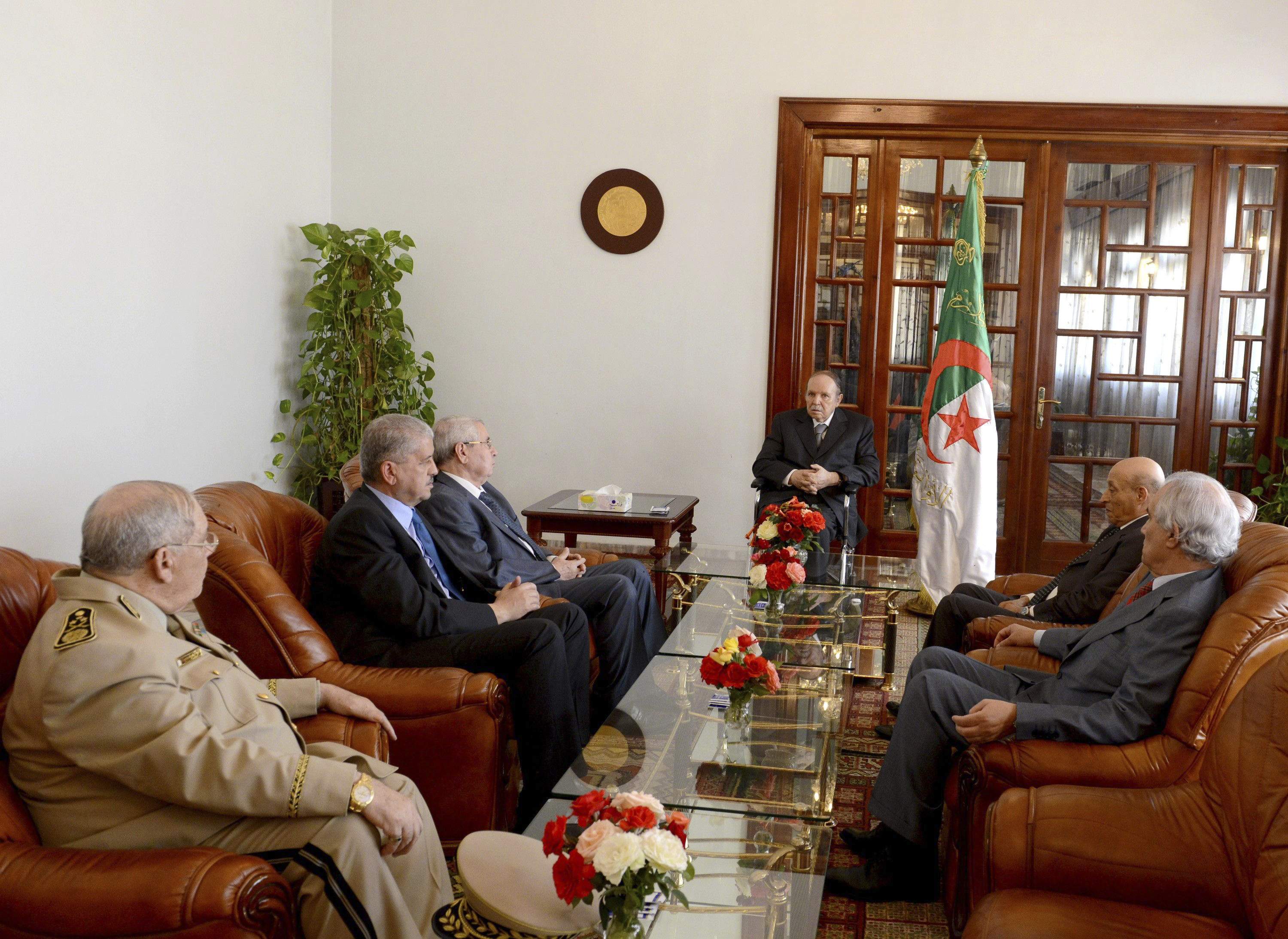 Algeria's President Abdelaziz Bouteflika (C) meets his ministers upon his arrival at Boufarik Airport in this handout picture provided by the official APS news agency July 16, 2024