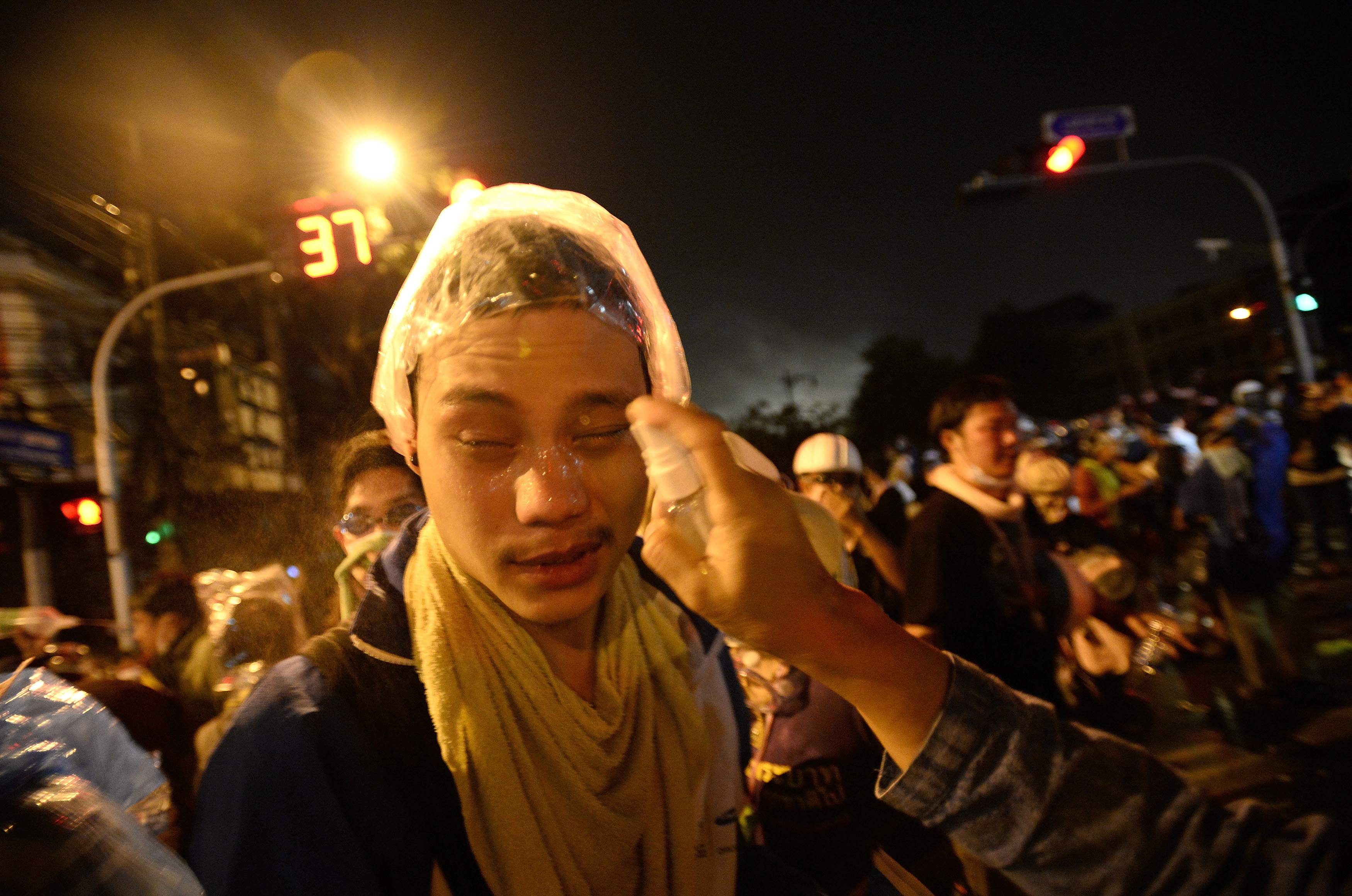 Anti-government protesters are treated after Thai riot police fired tear gas as protesters attacked Government House in Bangkok December 2, 2013. REUTERS/Dylan Martinez