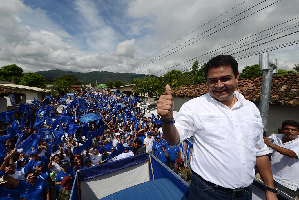 The president of the Honduran Congress and presidential candidate for the ruling Partido Nacional, Juan Orlando Hernandez (R) waves to supporters during a rally in Azacualpa, Santa Barbara, 300 km west of Tegucigalpa, on October 27, 2013. Honduras will hold general elections on November