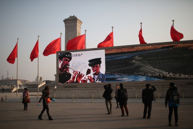 Chinese tourists watch a LED screen showing a promotional video of Xinjiang Uygur Autonomous Region ahead of the opening of the Chinese People's Political Consultative Conference (CPPCC) on March 2, 2024 in Beijing, China. Feng Li/Getty Images