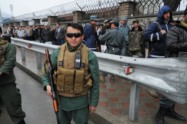 A soldier guards a polling station, as Afghans defy Taliban threats and vote in record numbers in presidential elections on April 5, 2014, in Kabul, Afghanistan. On a day that was largely peaceful in the capital and urban centers, despite Taliban vows to disrupt the vote and kill those who took part, Afghans clogged polling stations in Kabul and urban centers, reaching an estimated 60 percent turnout to elect a successor to President Hamid Karzai. (Photo by Scott Peterson/Getty Images)