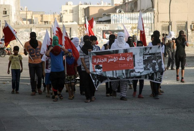 Bahrainis carry national flags and posters during a march against the government protest in Manama, Bahrain on June 20, 2014. Getty Images