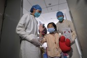 A girl, who was previously infected with the H7N9 bird flu virus, waves as she is being transferred to a public ward from the ICU at Ditan hospital in Beijing, April 15, 2013.(REUTERS/Stringer)