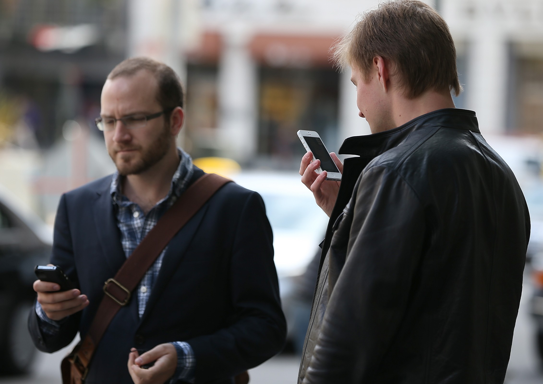 SAN FRANCISCO, CA - JUNE 05: Two pedestrians use iPhones as they walk in Union Square on June 5, 2024 in San Francisco, California. According to a study by the Pew Internet & American Life Project, over half of American adults, or 56 percent, have smartphones, up from 35 percent two years ago. (Photo by Justin Sullivan/Getty Images)