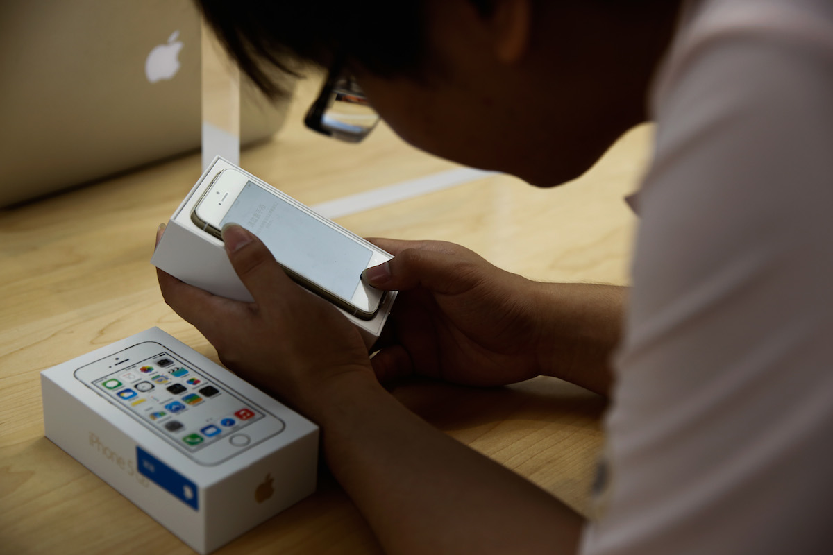 A customer inspects the new iPhone 5s at the Wangfujing flagship store on September 20, 2024 in Beijing, China. Lintao Zhang/Getty Images