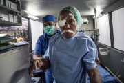 A patient is assisted by a nurse as he leaves the mobile eye clinic in Indonesia. Agung Parameswara/Getty Images