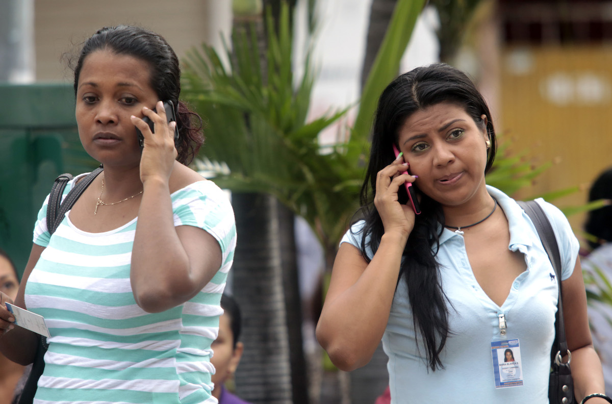 Women speak on their mobile phones in Acapulco, Mexico. AFP PHOTO / Pedro PARDO