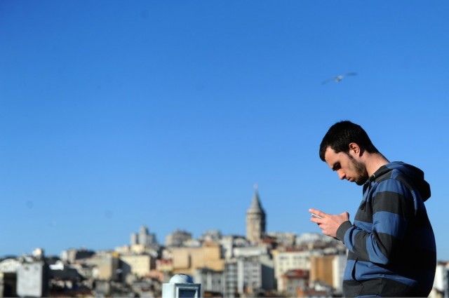 Turkish man uses his phone in the Eminonu district of Istanbul. AFP PHOTO / OZAN KOSE