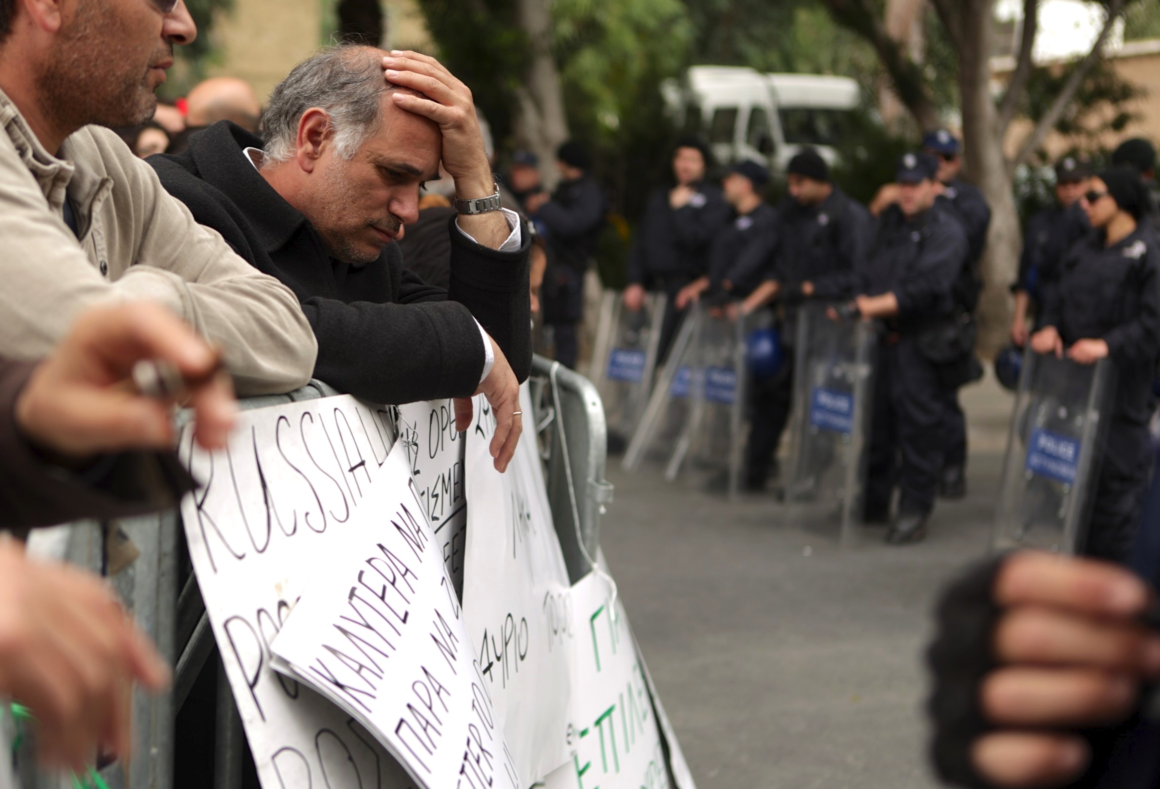 An employee of Cyprus Laiki Bank takes part in a protest.