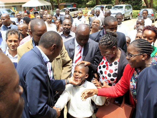 Kenya's newly elected President Uhuru Kenyatta greets a boy after arriving at St. Austine Church in capital Nairobi March 31, 2013. REUTERS/Noor Khamis