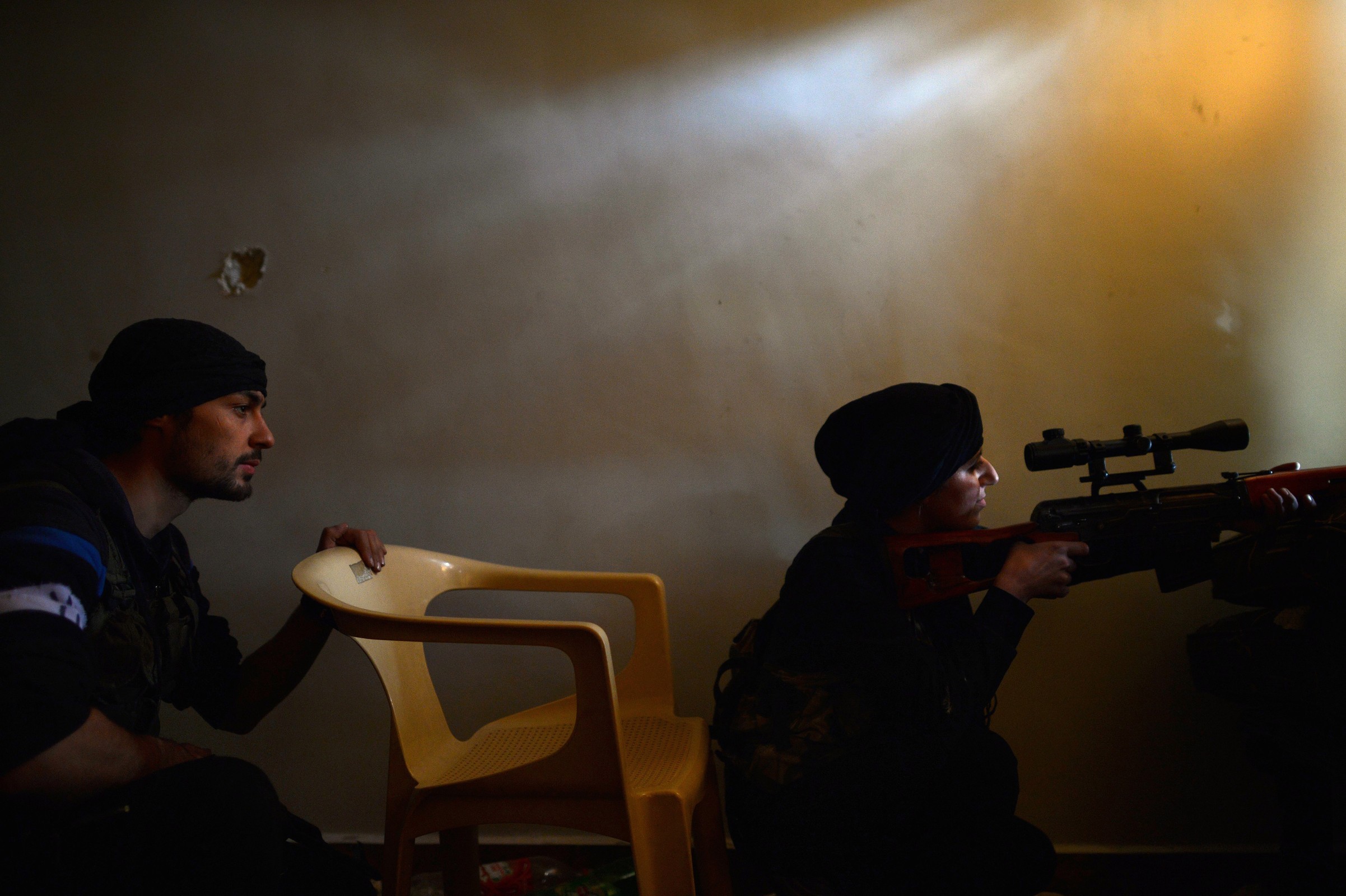 A Syrian rebel monitors the movement of Syrian government forces in the Sheikh Maqsud district of the northern Syrian city of Aleppo, on April 11, 2013.
