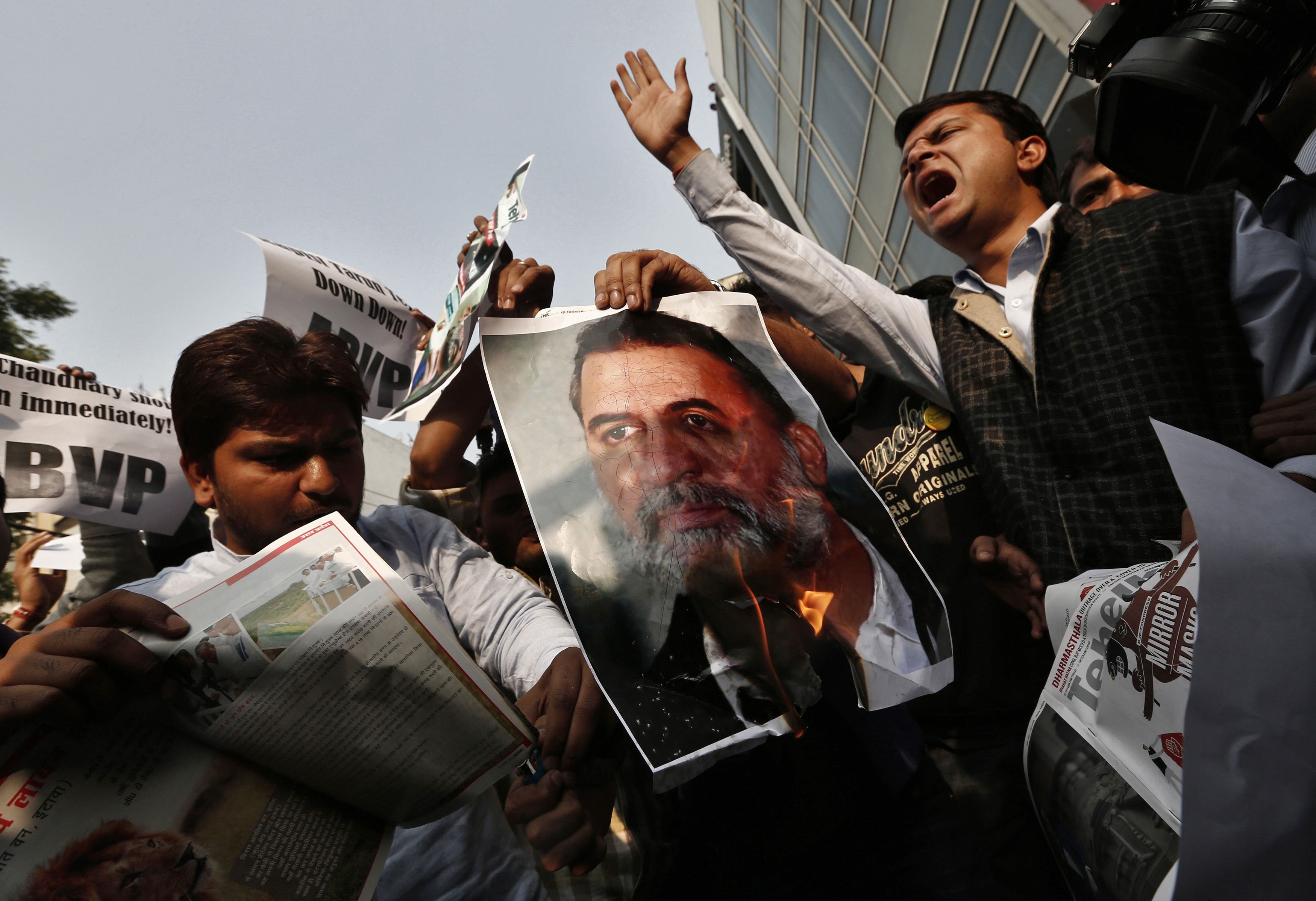 Activists burn a poster of Tarun Tejpal in New Delhi November 22, 2013. (REUTERS/Adnan Abidi)