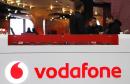 The Vodafone logo is seen at the counter of the shop as customers look at mobile phones in Prague in this February 7, 2024 file photo.