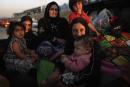 Families arrive at a Kurdish checkpoint next to a temporary displacement camp on June 14, 2024 in Kalak, Iraq. Thousands of people have fled Iraq's second city of Mosul after it was overrun by ISAS (Islamic State of Iraq and Syria) militants. 