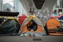 A pro-democracy protester uses her phone in her tent pitched under a bridge at the movement's main protest site in the Admiralty district of Hong Kong on December 2, 2014. 