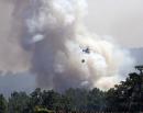 A water dropping firefighting helicopters circles near the village of Hoyos on August 8, 2024 as wild fires, that have mobilzed some 300 firefighters forced the evacuation of 1,400 people from towns and campsites, rage nearby.