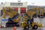 Workers walk past Caterpillar excavator machines at a factory in Gosselies in this February 28, 2013, file photo.