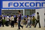 In this file photo taken on May 22, 2010, visitors to a job fair walk past the Foxconn recruitment area in Shenzhen in south China's Guangdong province.