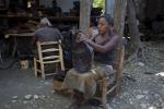 In this Dec. 11, 2012 photo, Marleine Land, 24, creates a decorative wooden bowl at the Einstein wood shop in Carrefour, Haiti.