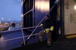 A striking dock workers stands at the entrance of an idle ferry, at the port of Piraeus, near Athens, on Tuesday, Feb. 5, 2013.