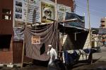 In this Sunday, March 17, 2024 photo, an Egyptian man walks past banners hung up by members of Gamaa Islamiya in front of el-Gamaayah el-Sharaayah mosque also used as Gamaa's headquarters, not pictured, in Assiut, southern Egypt. 