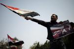 An Egyptian protester waves his national flag while holding a poster of slain former Egyptian president Anwar Sadat with a slogan reading in Arabic 'Man of war and peace' during a demonstration in support of the Egyptian army and against the Muslim Brotherhood in Cairo on March 1, 2013.