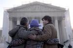 A group from Alabama prays in front of the Supreme Court in Washington, Wednesday, March 27, 2013, before the court's hearing on the Defense of Marriage Act (DOMA). In the second of back-to-back gay marriage case, the Supreme Court is turning to a constitutional challenge to the law that prevents legally married gay Americans from collecting federal benefits generally available to straight married couples. (AP Photo/Carolyn Kaster)