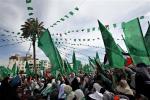 Palestinian women wave green Islamic and national flags during a support rally for Palestinian prisoners who are held at Israeli jails, in Gaza City, Thursday, April 11, 2013. Nearly 5,000 Palestinians are being held in Israeli prisons according to prisons authority spokeswoman Sivan Weizman. (AP Photo/Adel Hana)
