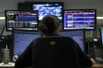 A broker works in a trading room of a Portuguese bank in Lisbon, Tuesday, May 7, 2013.