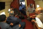 Sudan's President Omar al-Bashir (R) and other officials look out an aircraft window as they fly over an area affected by floods caused by heavy rains in Khartoum August 5, 2013. 