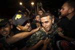 A released Palestinian prisoner, Nehad Jondiya, center, laughs as relatives and friends gather around him upon his arrival to his family house in Gaza City, Wednesday, Aug. 14, 2013. 