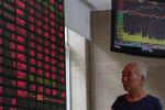 An investor looks at a stock prices monitor at a private securities company Monday, Aug. 26, 2013 in Shanghai, China.
