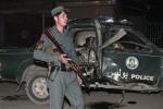 A member of the Afghan security forces secures the area at the scene of an explosion with a destroyed police car behind, in Kabul, Afghanistan, Friday, Sept. 20, 2013. 