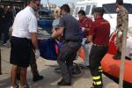 Firefighters unload the body of a drowned migrant from a Coast Guard boat in the port of Lampedusa, Sicily, Thursday, Oct. 3, 2013.