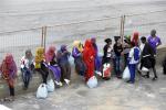 Migrants wait to board a ferry boat from the port of Lampedusa, for Sicily, southern Italy, where they will be sent to other temporary camps based on their legal status, Monday, Oct. 7, 2013.