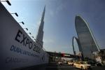 n this Wednesday Nov. 20, 2013, with the Burj Khalifa, the world's tallest building in the background, vehicles pass by a billboard advertising Dubai as a candidate city for the Expo 2020 in Dubai, United Arab Emirates.