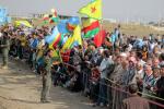 Syrian Kurds wave flags as they gather on the border with Turkey, near Mardin's Nusaybin district, on November 7, 2013. 