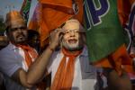 A supporter of Bharatiya Janata Party (BJP) leader Narendra Modi puts on a mask showing the leader at an event before Modi filed his nomination papers on April 9, 2024 in Vadodra, India. 