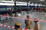Police and train station workers stand near the site of a bomb attack at a train station in Chennai.