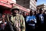 NAIROBI, KENYA - MAY 16: A soldier in the Kenya Defense Forces (KDF) keeps control of onlookers after two improvised explosive devices (IED) went off in Gikomba market on May 16, 2024 in Nairobi, Kenya. Two improvised explosive devices (IED) were activated, killing several people and injuring more than 70. One person has been apprehended as a suspect in the attack. Credit Christena Dowsett/Getty Images