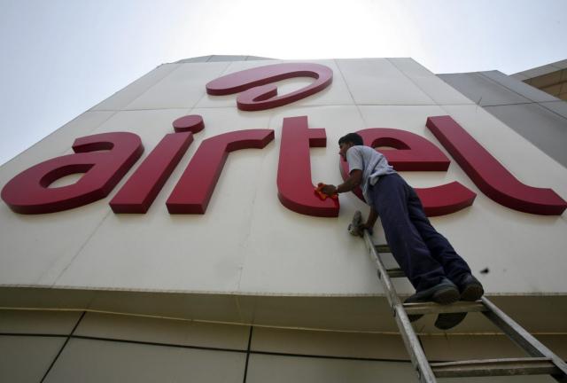 A worker cleans a logo of Bharti Airtel at its zonal office building in the northern Indian city of Chandigarh May 2, 2013. 