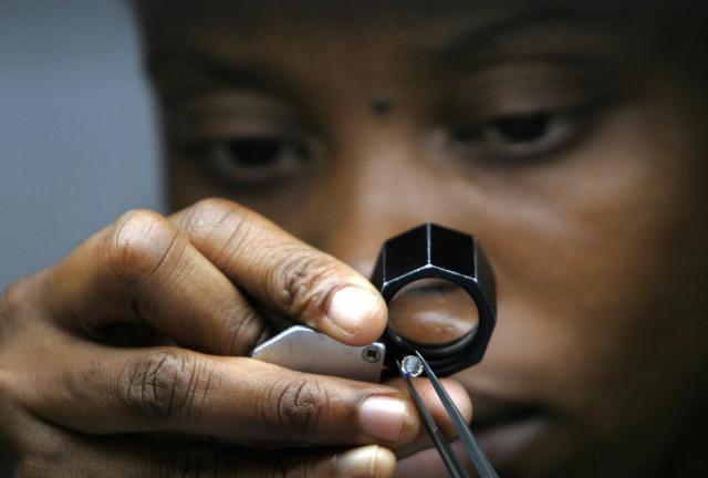 A diamond cutter checks a 2 carat diamond in Gaborone on March 18, 2008.