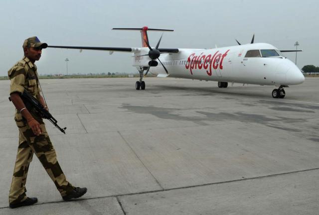 Indian airport security watch the arrival of a SpiceJet flight from Delhi to Amritsar on July 12, 2012.