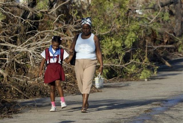 A student walks to school past trees that fell during the passing of Hurricane Sandy in Santiago de Cuba, Cuba, Monday, Nov. 5, 2012. Classes resumed Monday in a sign of some return to normalcy. But more than 100 schools remain shuttered due to storm damage. 